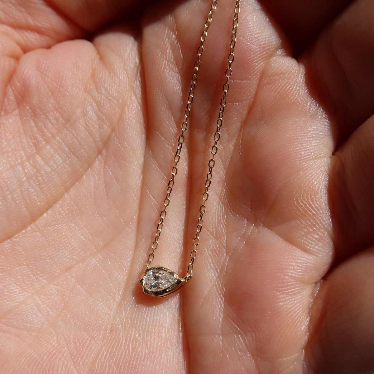 melted pear diamond bezel necklace in 10 karat yellow gold